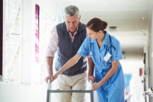 Nurse helping senior man with walking aid